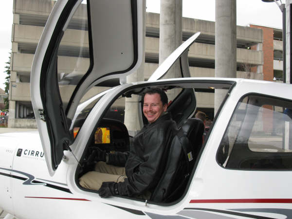 Yuri Kovchegov sitting in the cockpit of a plane while smiling