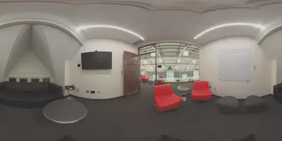 panoramic photo of small meeting room with bright red chairs